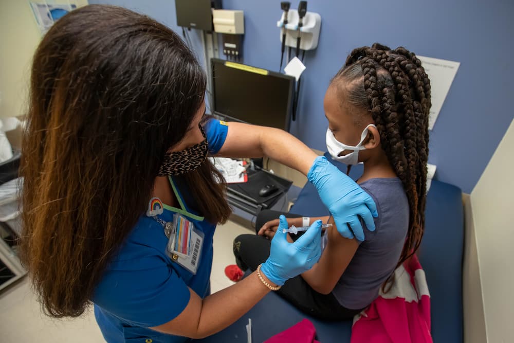 In this file photo, nurse manager Gretchen Holloway gives Jayla Smith of Jackson a vaccination protecting her from COVID-19.